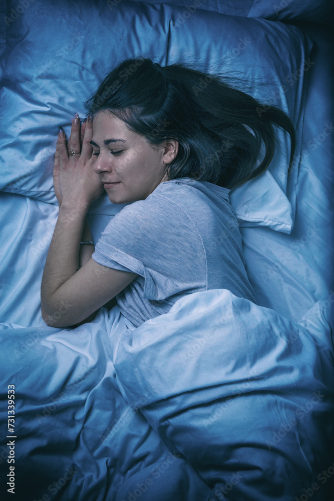A beautiful girl is sleeping in a bed with a white sheet A beautiful girl is sleeping in a bed with a white sheet