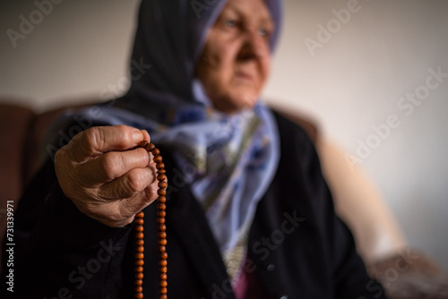 The old Muslim grandmother holds the rosary in her hands. © Stockseller33