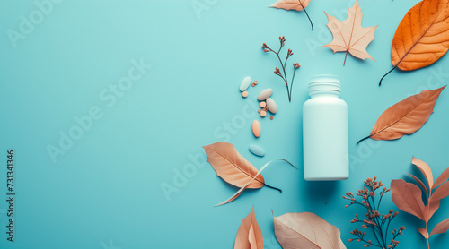 Bottle of pills and leaves on blue background. Copy space