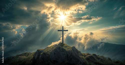 Crucifix at the top of a Mountain with Sunlight Breaking through the Clouds. Inspirational Christian Image. photo