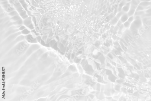 White water with ripples on the surface. Defocus blurred transparent white colored clear calm water surface texture with splashes and bubbles. Water waves with shining pattern texture background.