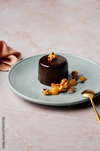 Flourless chocolate cake with mirror glaze, salted caramel popcorn and mandarin gel photo