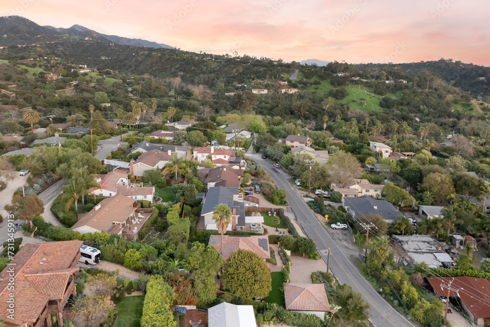 Fototapeta premium a city with hills and houses next to trees and grass