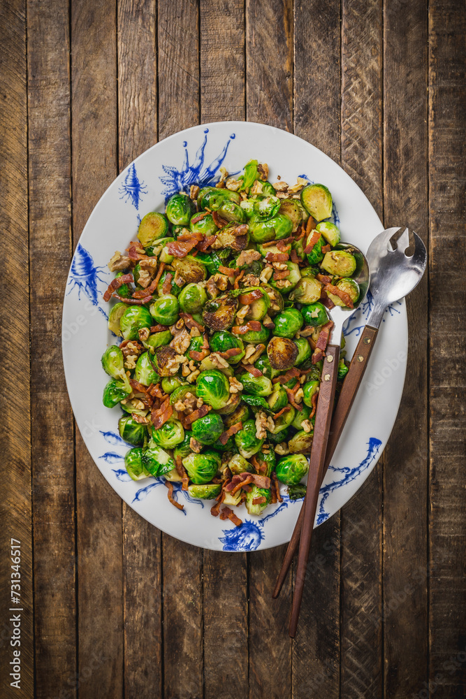 Sauteed brussels sprouts and bacon on white and blue platter Sauteed brussels sprouts and bacon on white and blue platter