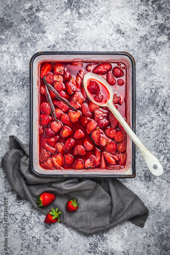 Roasted strawberries in an enameled tray with vanila pod photo