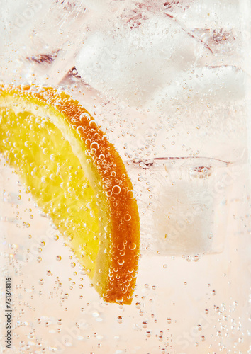 Lemonade in a glass with fizzy bubbles and a slice of orange