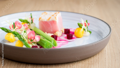 Close up of Tuna and Fresh vegetable appetizer on white plate with wooden background