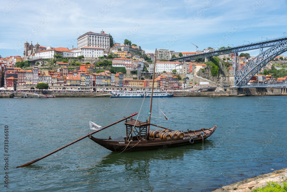 Histórico barco de transporte de vino, en el río Tajo y vista del barrio de Ribeira en Oporto, Portugal