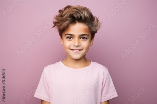 Portrait of a smiling little girl in a pink t-shirt on a purple background