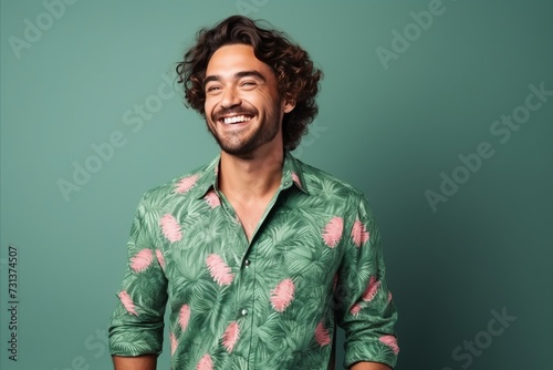 Portrait of a smiling young man in a green shirt over green background
