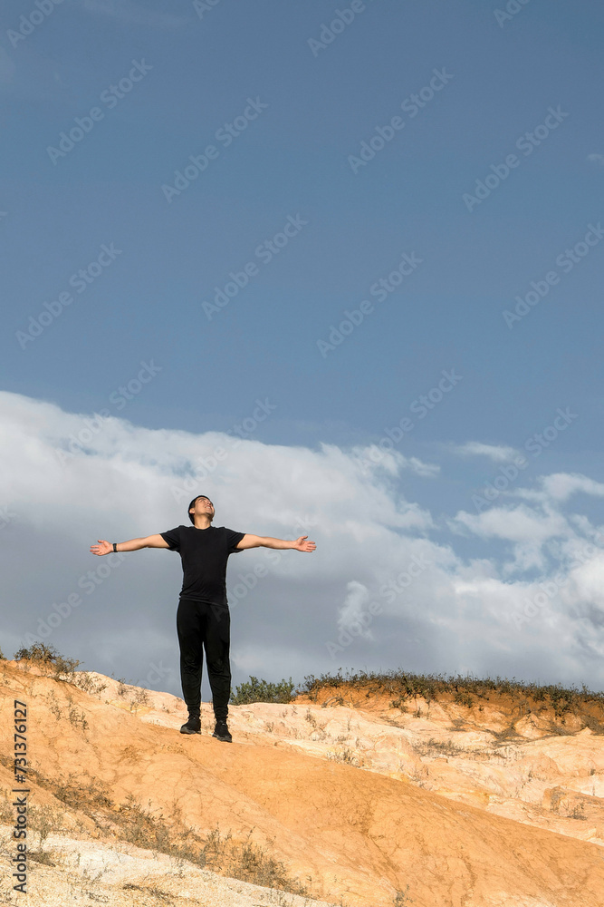 Happy man spreading his hands and looking at the sky thanking on top of the mountain with space for text Happy man spreading his hands and looking at the sky thanking on top of the mountain with space for text