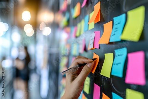 A person's artistic expression comes to life on a blackboard, adorned with colorful post-it notes, creating a vibrant and captivating street scene indoors