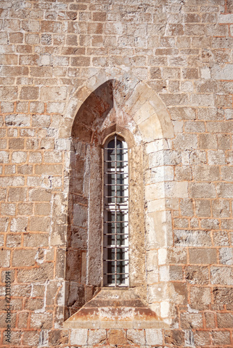 Stone wall with a church window in the old town