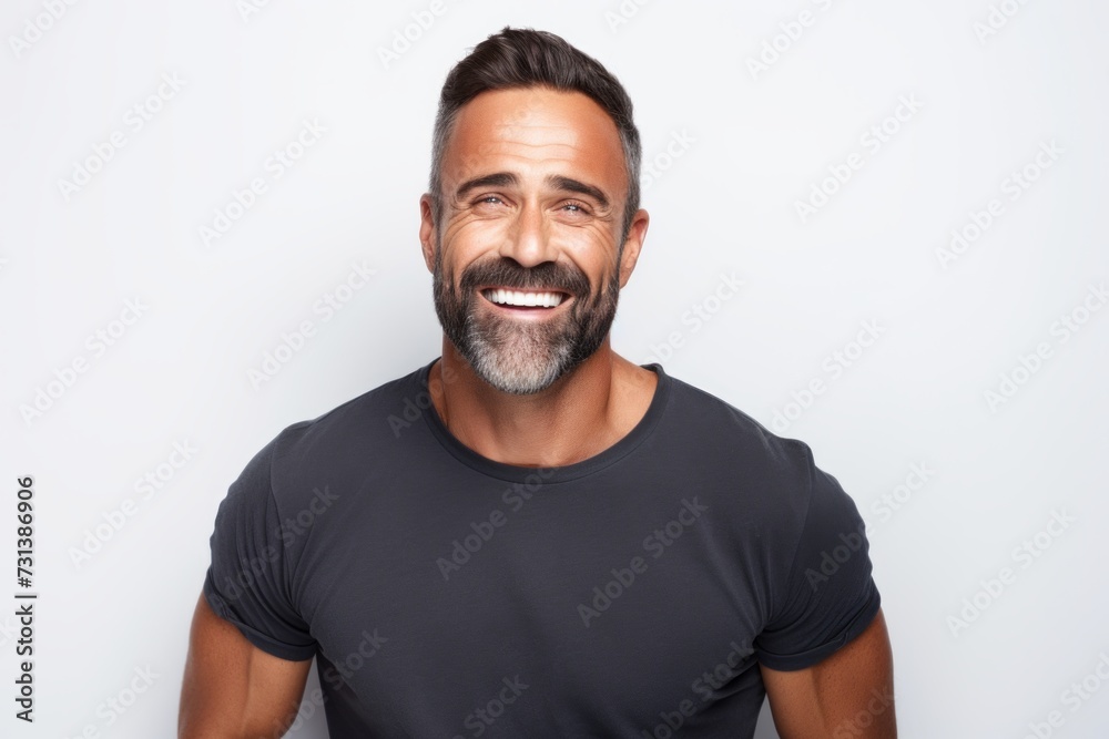 Portrait of a handsome middle-aged man smiling while standing against grey background Portrait of a handsome middle-aged man smiling while standing against grey background