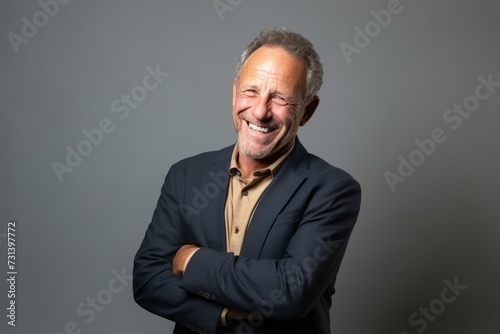 Portrait of a happy senior man smiling at the camera with arms crossed