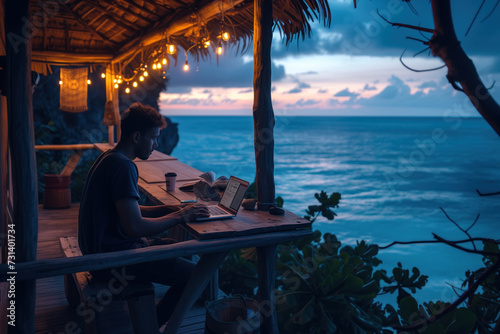 Remote Work Concept: Person Working on Laptop at a Beachfront Cabin During Sunset