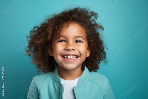 Portrait of a smiling little african american girl on blue background