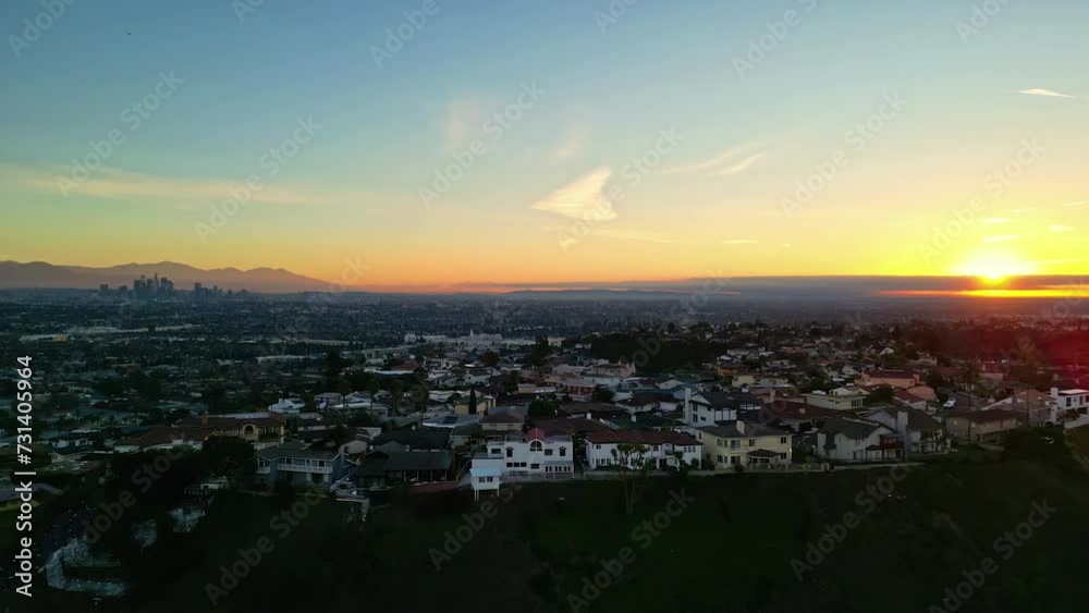 Aerial drone shot of sun rising over houses in Kenneth Hahn Recreational Area during morning time in Los Angeles, CA, USA. Aerial drone shot of sun rising over houses in Kenneth Hahn Recreational Area during morning time in Los Angeles, CA, USA.