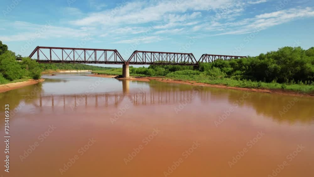 Aerial video flying low over the Red River in Texas. A train bridge is in front of the drone. Aerial video flying low over the Red River in Texas. A train bridge is in front of the drone.