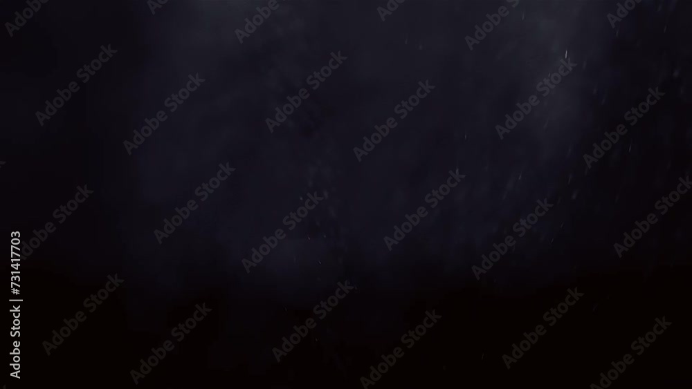 Misty spray water droplets shimmer in soft light as they fade against black background