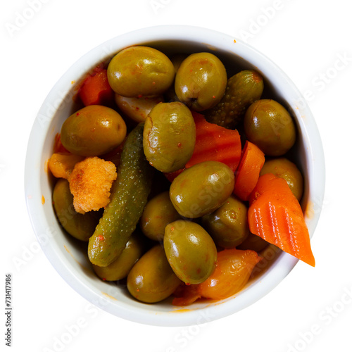 Assorted large olives served in bowl with pieces of pickled vegetables. Isolated over white background