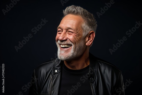 Portrait of a happy senior man with a beard on a black background.