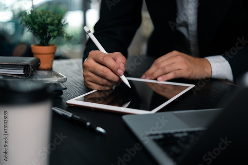 Businessman working hands a digital tablet with a stylus pen signing documents, modern creative work or design planning.