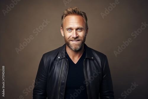 Portrait of a handsome mature man in a black leather jacket. © Inigo