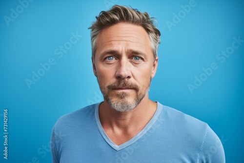 Portrait of a handsome middle-aged man on blue background.