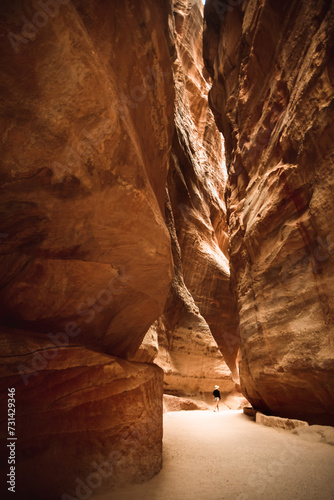 Tourist on The Siq, the narrow slot-canyon that serves as the entrance passage to the hidden city of Petra, Jordan