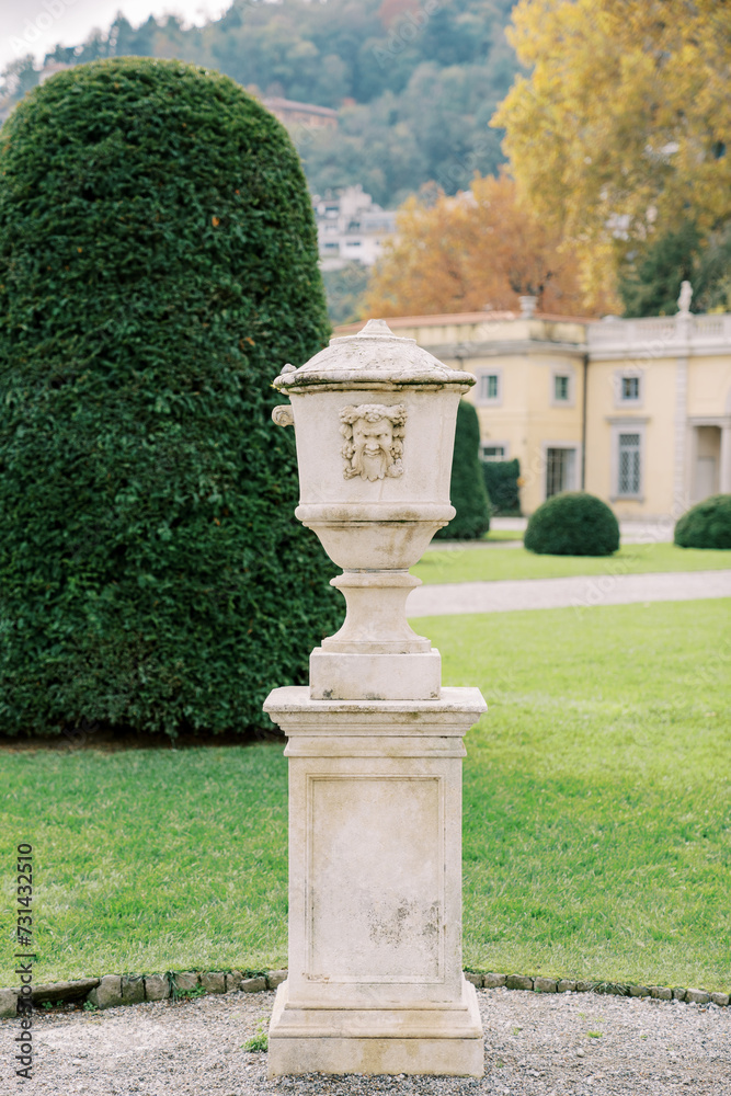 Marble flowerpot with lid in the green garden of an ancient villa