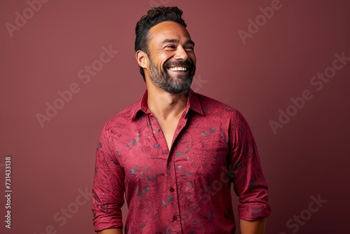 Handsome Indian man in a red shirt on a purple background
