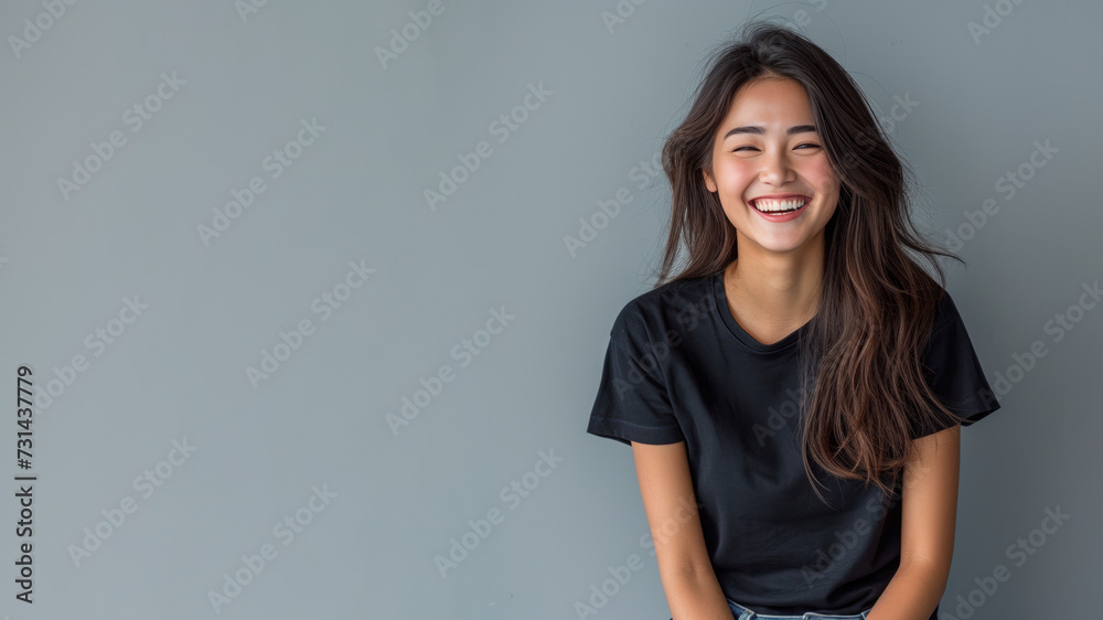 Asian young woman wear black t-shirt smile isolated on grey background - obrazy, fototapety, plakaty 