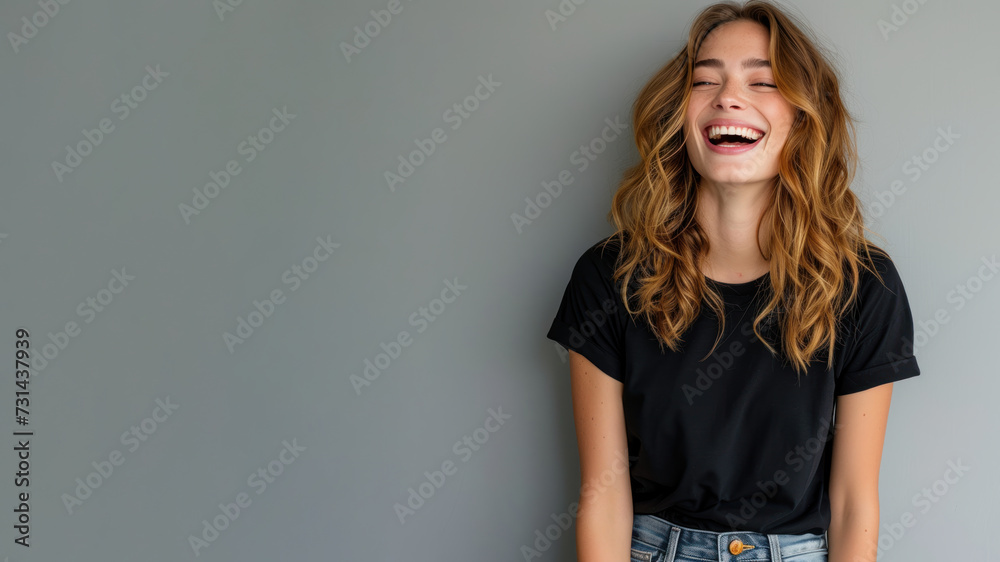 Caucasian young woman wear black t-shirt smile isolated on grey background Caucasian young woman wear black t-shirt smile isolated on grey background