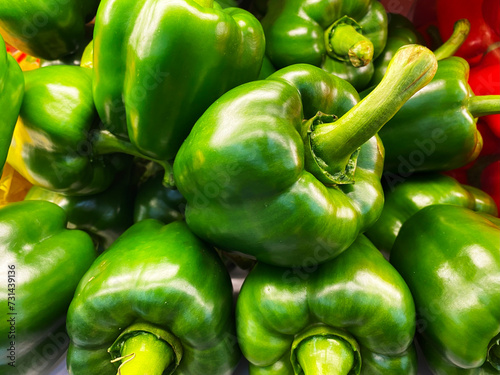 Freshly picked green bell peppers on display at the market photo