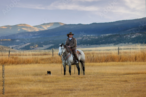 Colorado Cowboy on grey Quarter Horse with dog