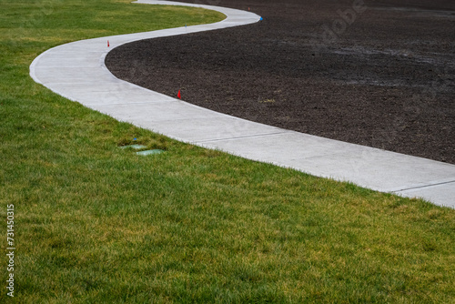 New lawn and sidewalk, and freshly prepared dirt ready for hydroseeding 