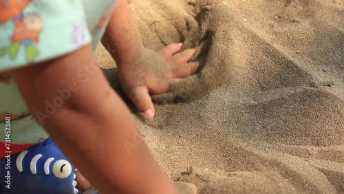 Child playing sand at the beach photo