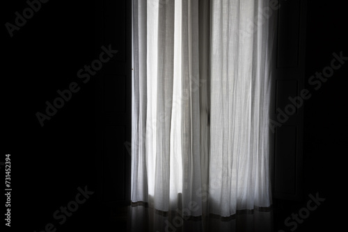 A photograph of a window in a dark room, covered with a light cloth.