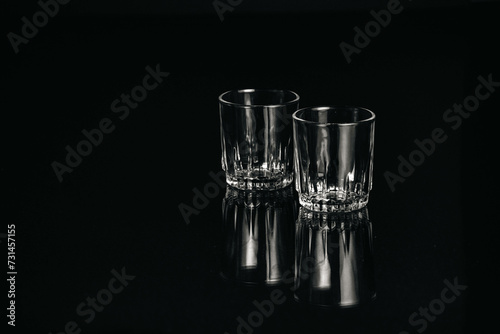 Black and white isolated empty Whiskey drinking crystal clear glasses with reflections and space for text