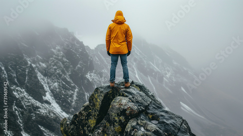 Man on top of mountain, concept for overcoming adversity and determination.  photo