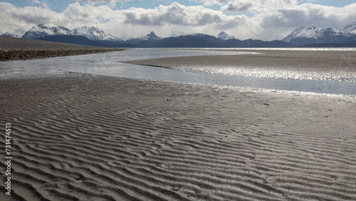 Tidal mud flats under cloudy skies on Homer Spit in Homer Alaska United States