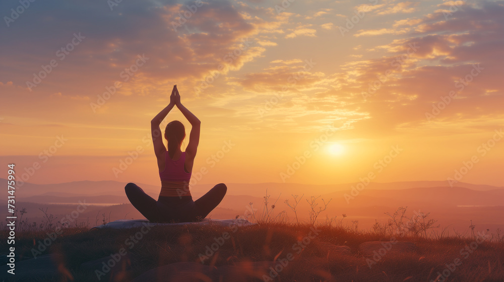 Silhouette of a peaceful person practicing yoga during a serene sunset in a tranquil outdoor setting