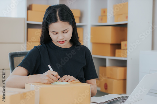 Small online SME business new startup Current online stores Young woman Chia checks orders and prepares packages for delivery to customers.