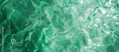 Top view of green water with natural sunlight shapes, creating an abstract crystal clear texture background and free space for designers. photo