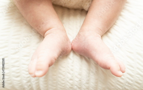 Newborn baby feet photographed on white background. Tiny baby feet closeup