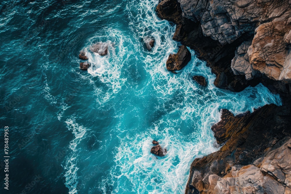 This breathtaking aerial shot captures the splendor of the ocean and rocks in one stunning display, A bird's eye view of turquoise sea waves crashing against enormous rocks, AI Generated