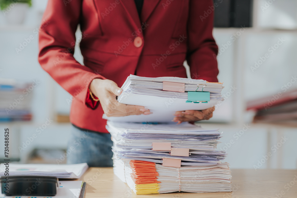 Woman's hands working in stacks of paper files to find and check unfinished documents, success in document folders at busy office Business document concept - obrazy, fototapety, plakaty 