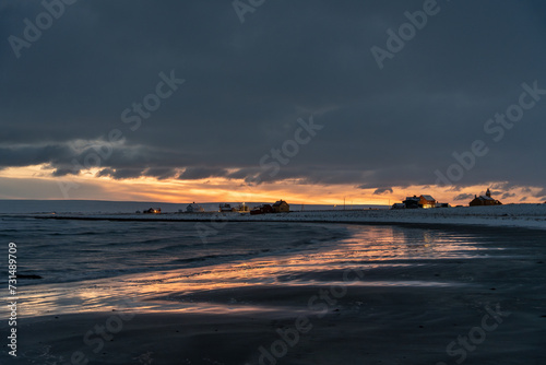 Moody afternoon sky and reflections on the wet sand by the sea on a winter afternoon during the polar night, Skallelv, Northern Norway photo