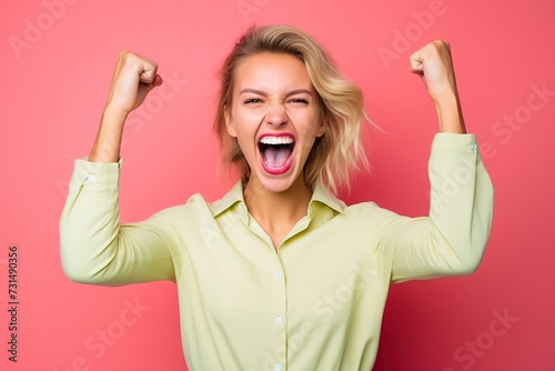 young female fighter with arms raised in victory with light shirt with pink background